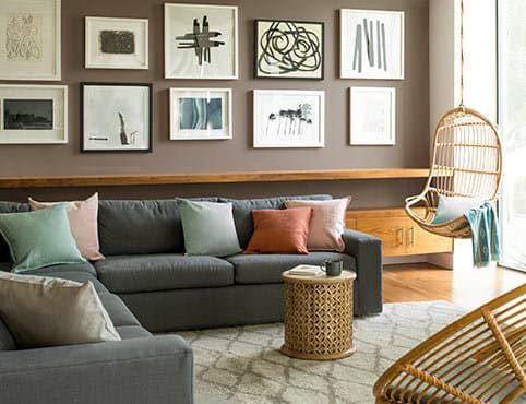 A living room with a couch, chair, table and pictures on the wall.